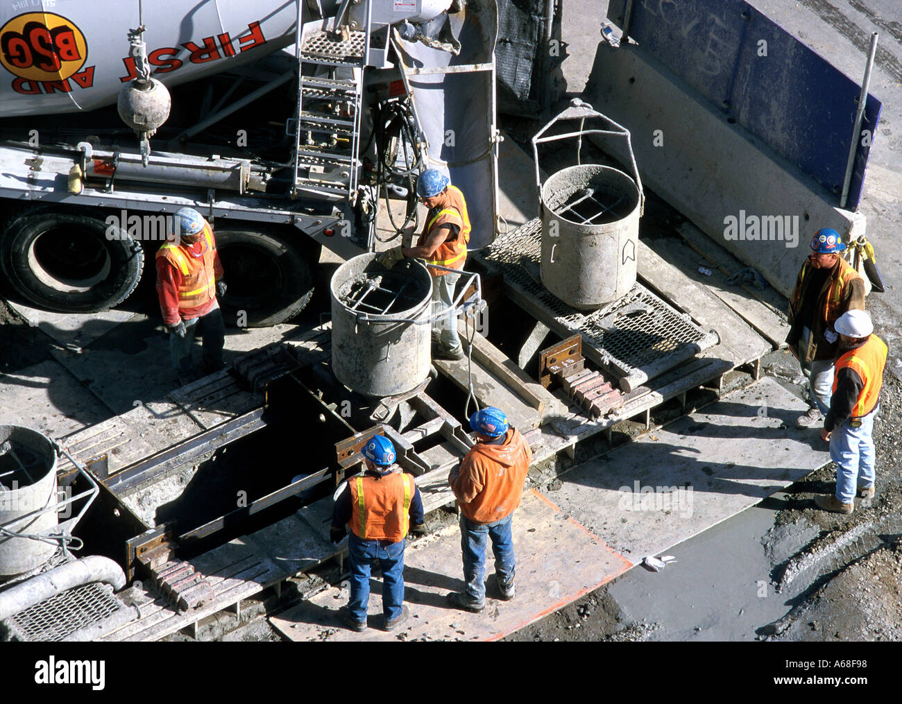 Lavoratori edili versare cemento ad un grande scavo sito in costruzione, Boston Foto Stock