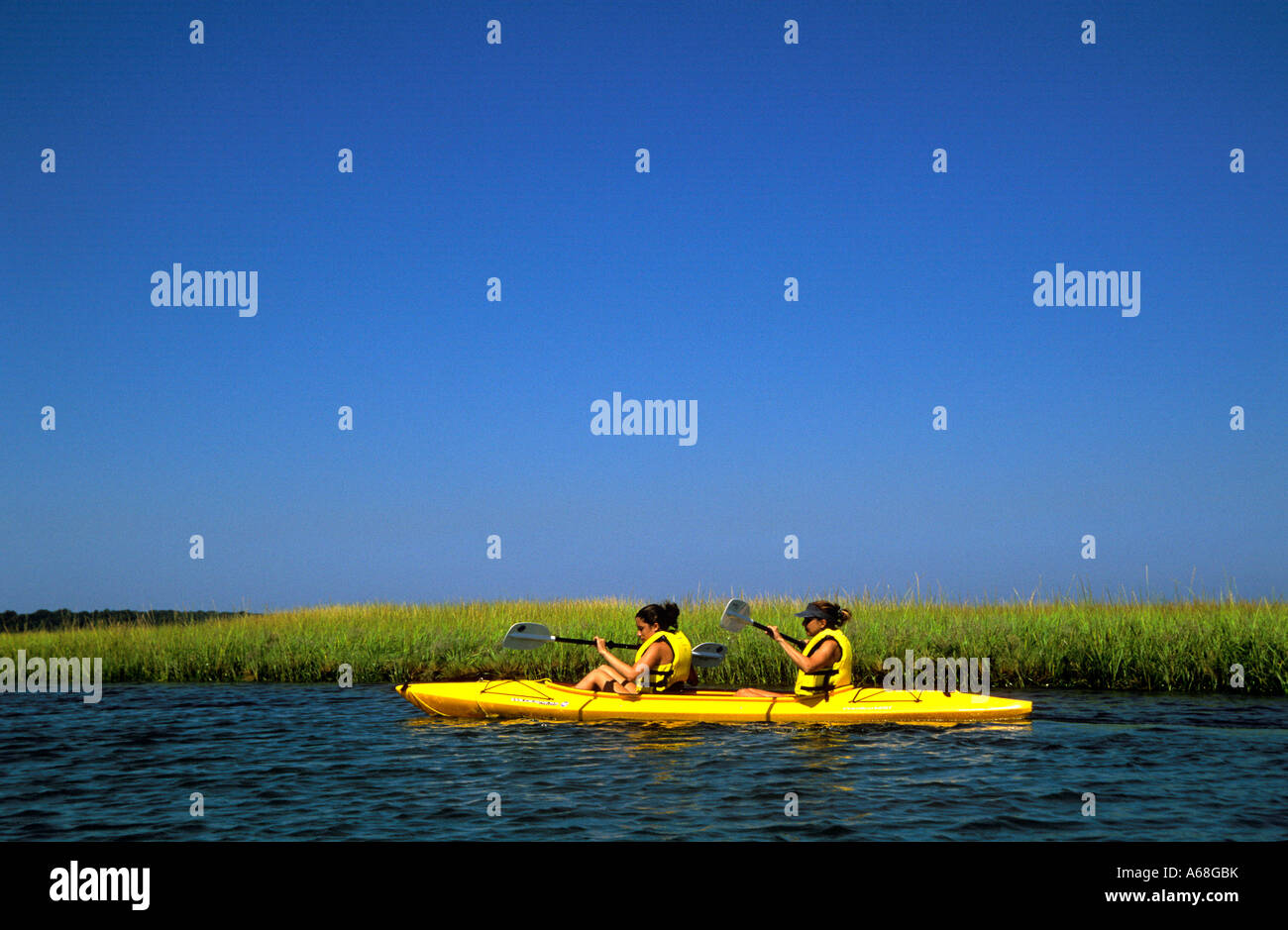 Due donne in tandem kayak navigazione attraverso erbe palustri lungo il Cape Cod National Seashore Eastham Cape Cod Foto Stock