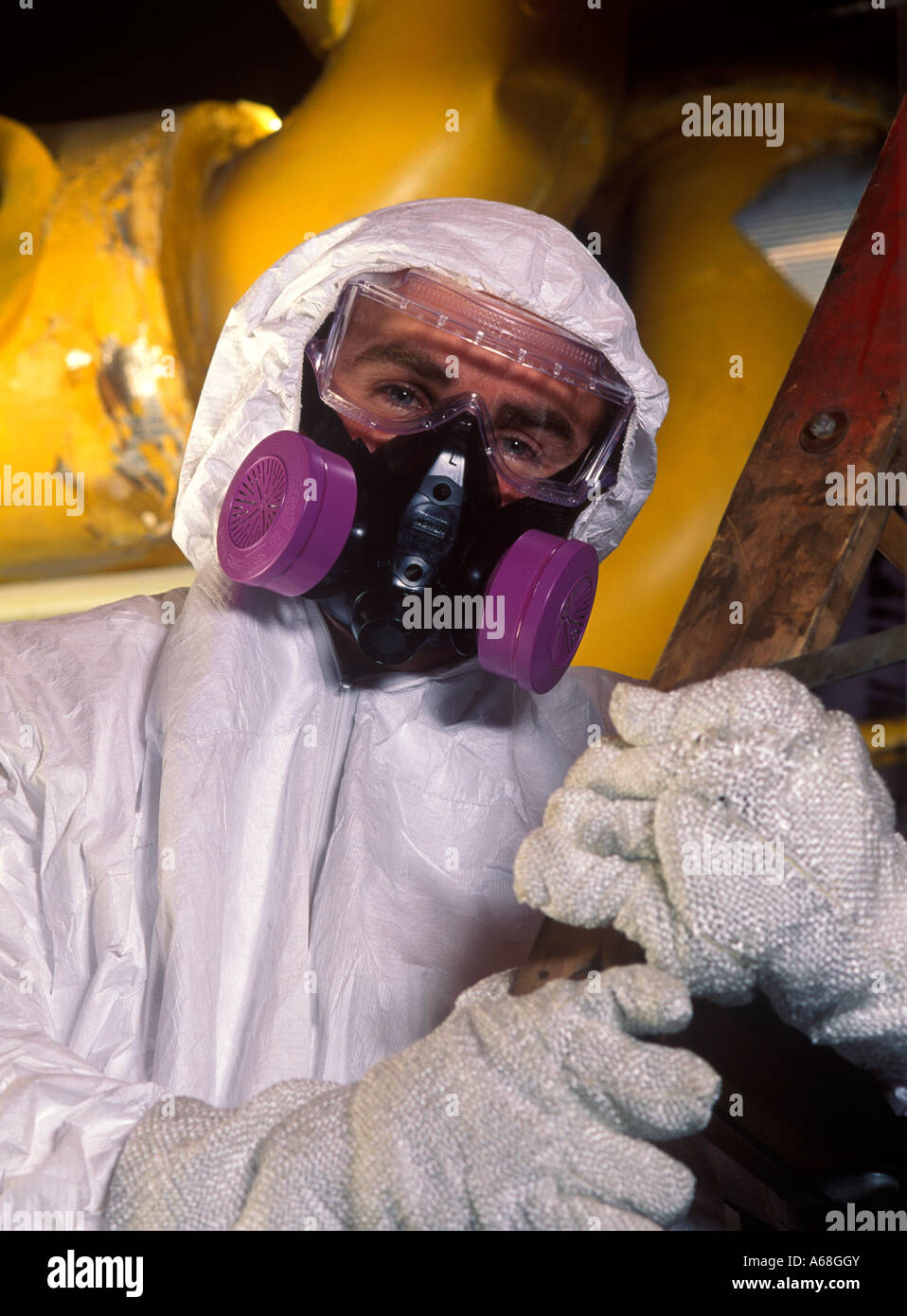 Rimozione amianto lavoratore con tuta protettiva e maschera in un sito industriale Foto Stock