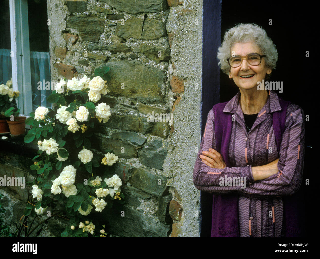 Sorridente ragazza irlandese alla porta della sua casa cottage Ramelton County Donegal Irlanda Foto Stock