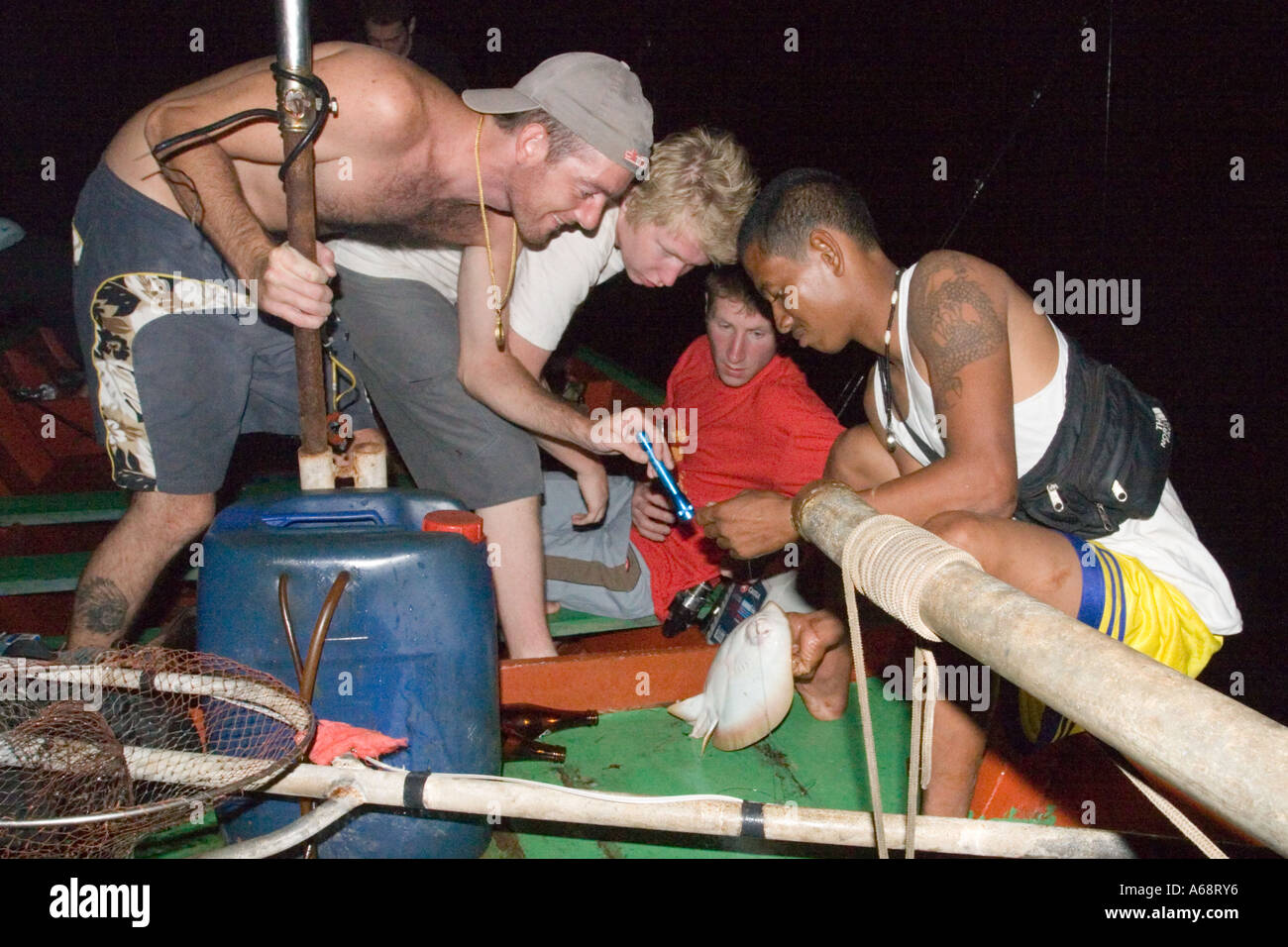 I turisti affollano un stingray catturati su una notte di spedizioni di pesca Foto Stock