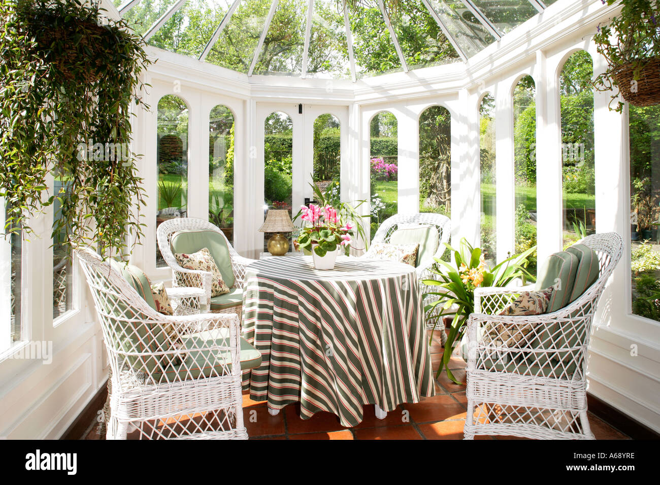 Interno della serra con bianco vimini mobili da giardino, Inghilterra. Foto Stock