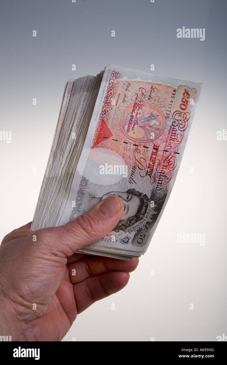 Mano che tiene la ventola di venti 50 pound note Foto Stock
