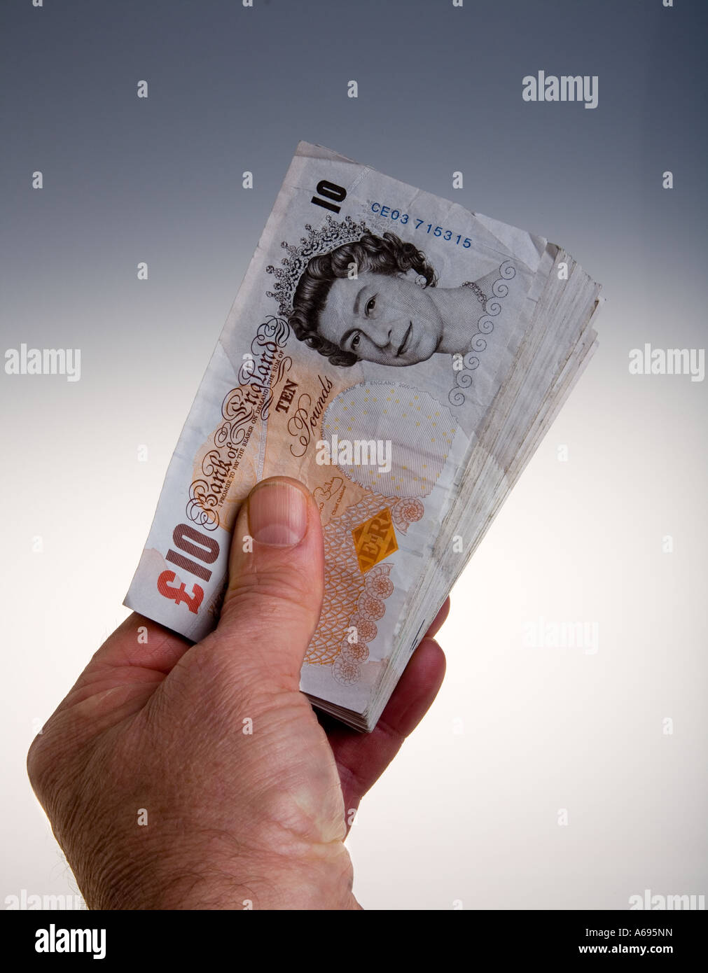 Mano che tiene la ventola di venti 10 pound note Foto Stock