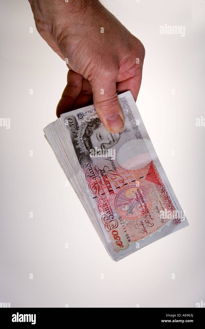 Mano che tiene la ventola di venti 50 pound note Foto Stock