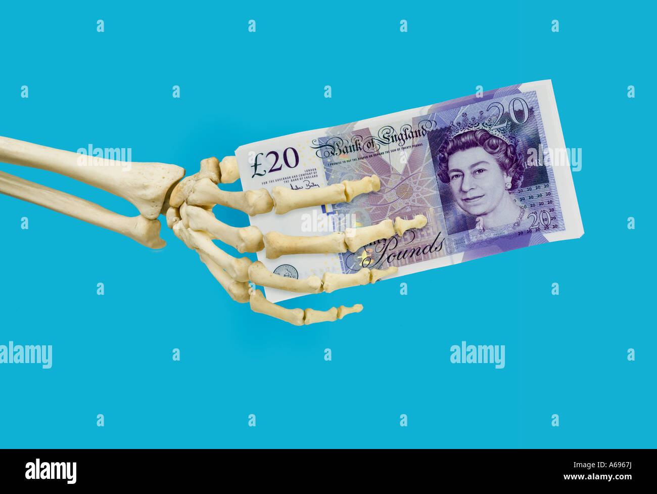 Scheletro umano mano destra tenendo new British venti 20 pound note Foto Stock