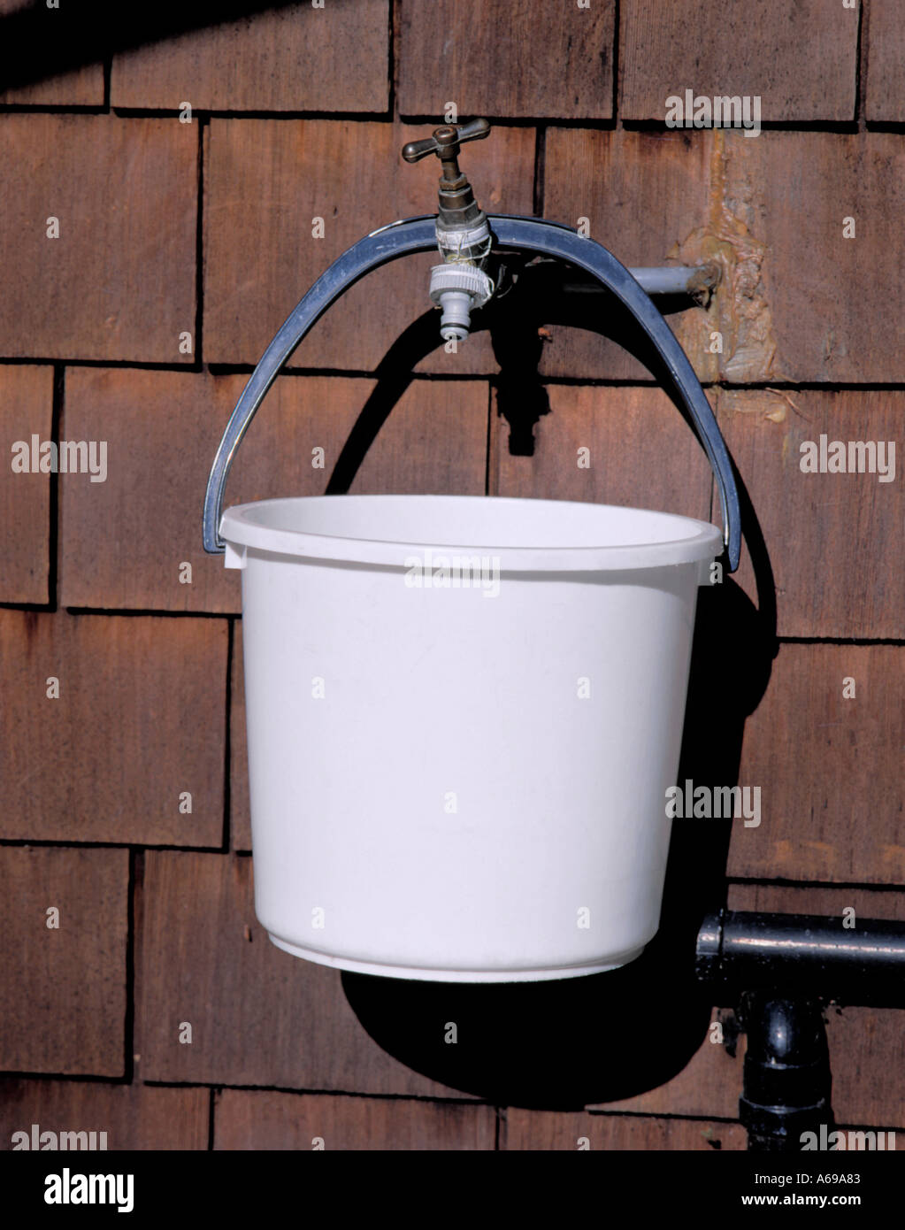 Secchio di plastica appesa per la maniglia dal giardino di ottone tocca Foto Stock