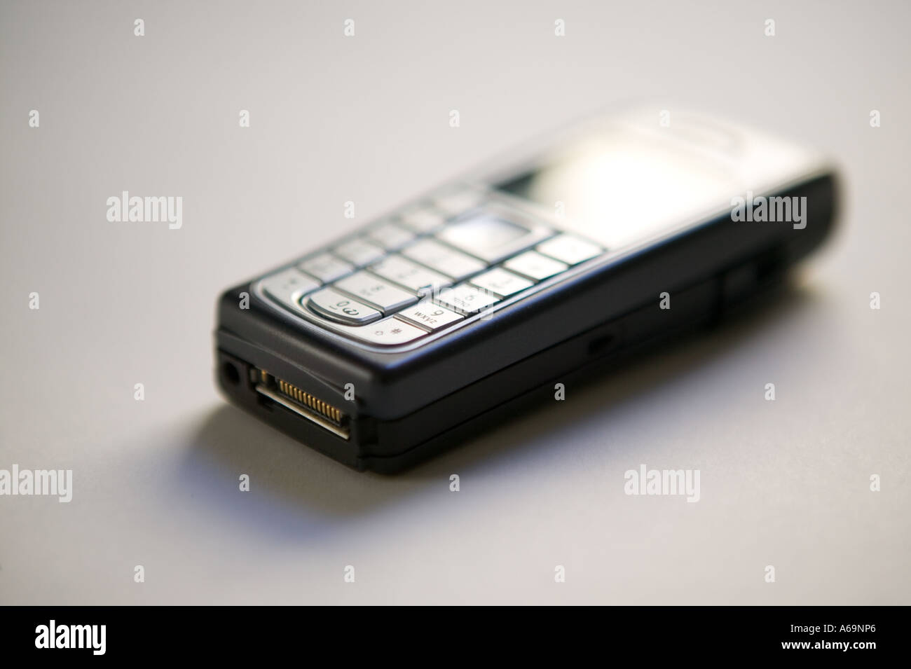 Studio shot di un telefono cellulare di un dispositivo su una superficie bianca 2006 Foto Stock