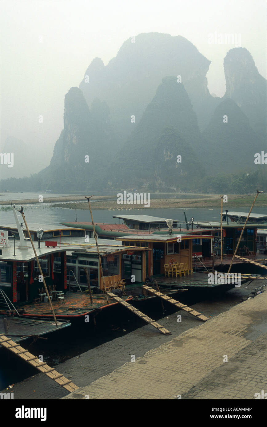 Li Jiang (Fiume Li), Xingping, traghetto tradizionale barche attraccate al bordo delle acque con fengcong spettacolari formazioni carsiche coperte Foto Stock