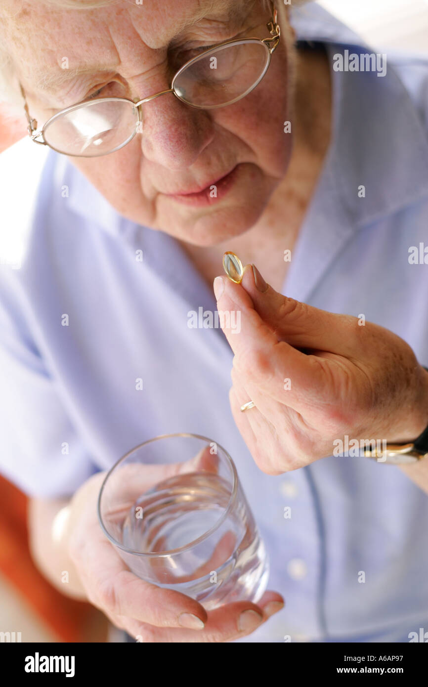 Donna anziana tenendo la capsula di olio Foto Stock