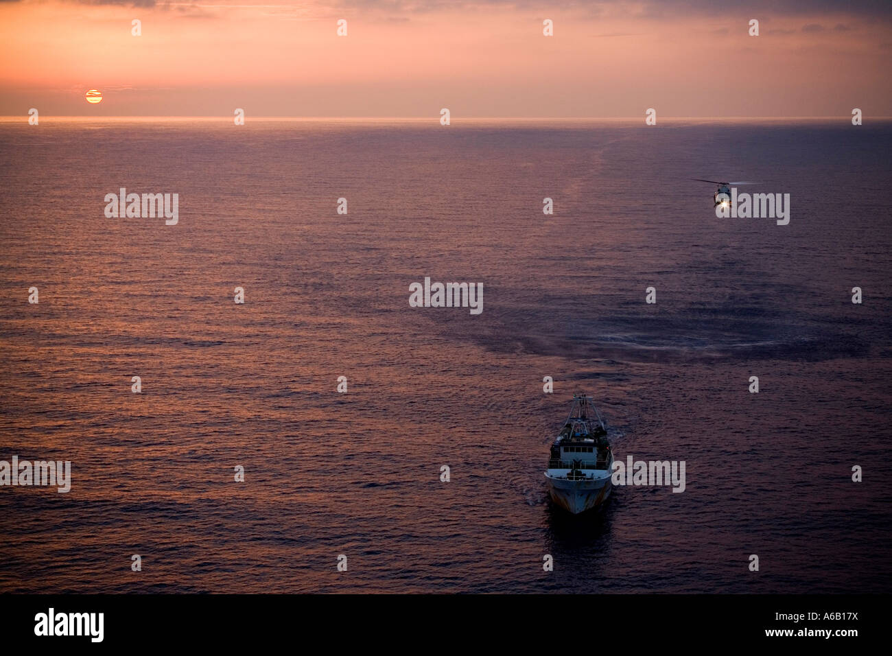 Guardia di Finanza elicottero abbassamento di una barca da pesca durante una ricerca e un'operazione di salvataggio in mare Mediterraneo. Foto Stock