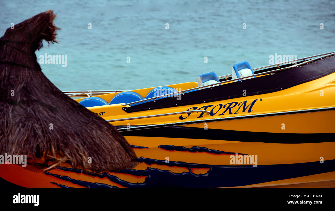 Giallo barca veloce "Storm" e paglia beach hut in Mauritius Foto Stock