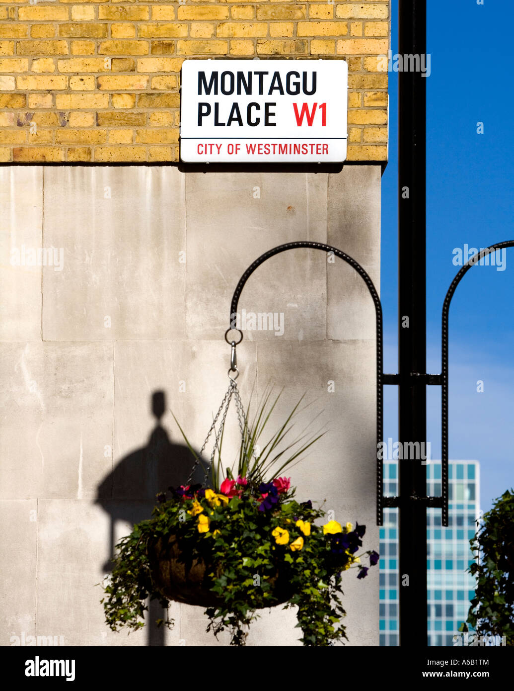 Un cartello stradale per Montagu Place, London, W1 con il candelabro e fiori Foto Stock
