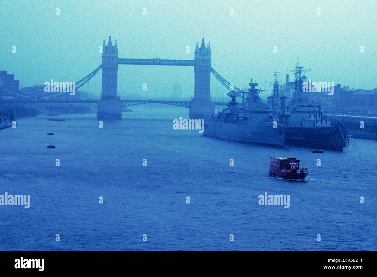 London Tower Bridge in una giornata nebbiosa e nebbiosa. Due navi da guerra sul Tamigi. Il traffico fluviale nella nebbia. Inghilterra storica Foto Stock