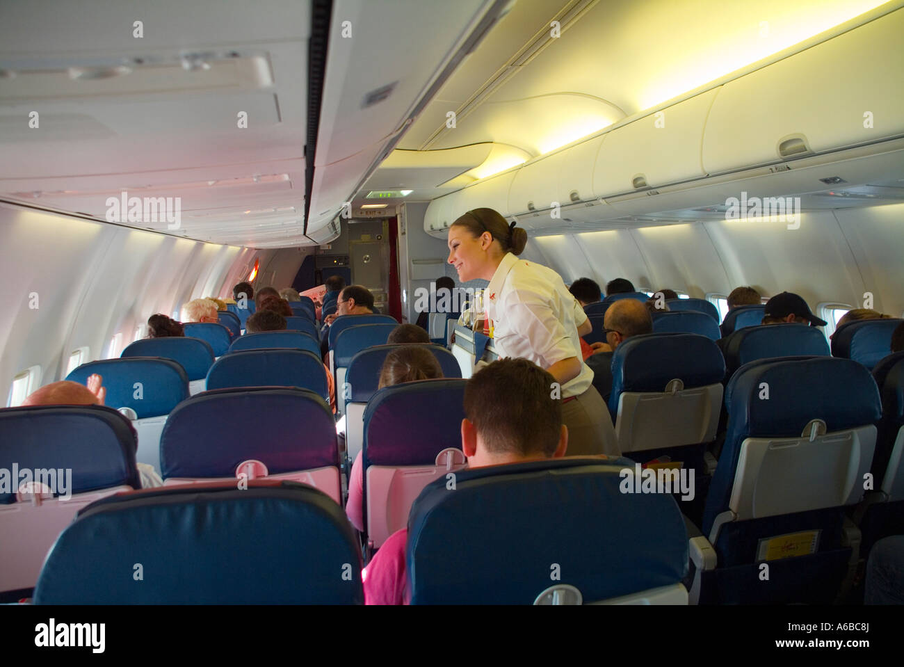 Un assistente di volo cercando dopo i passeggeri su una vergine aerei blu Foto Stock