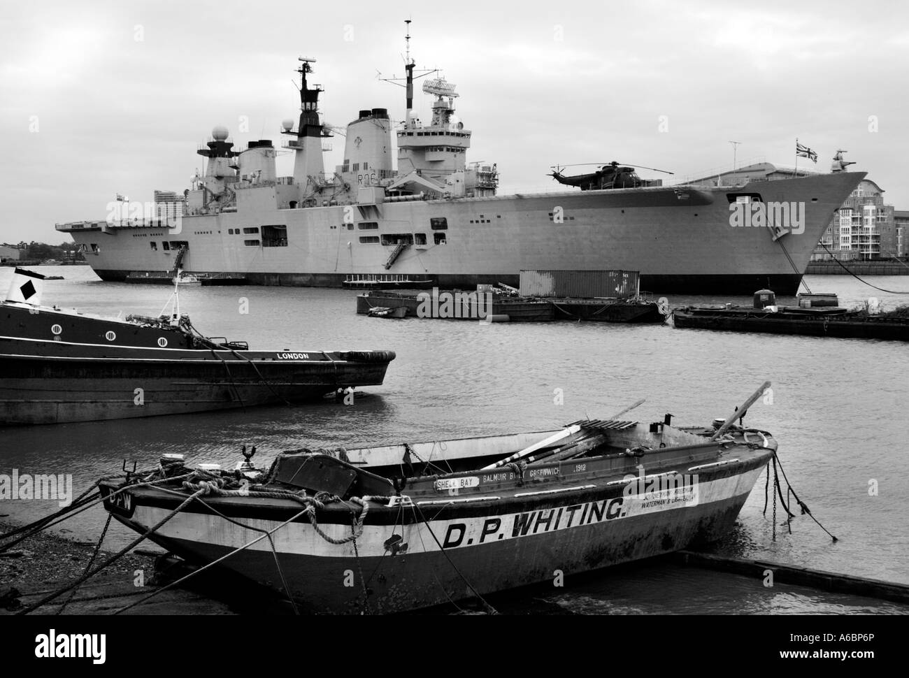 HMS illustre, Ormeggiata al pontile in legno, Greenwich, con barche di pescatori locali in primo piano. Immagine convertita a monochrom Foto Stock