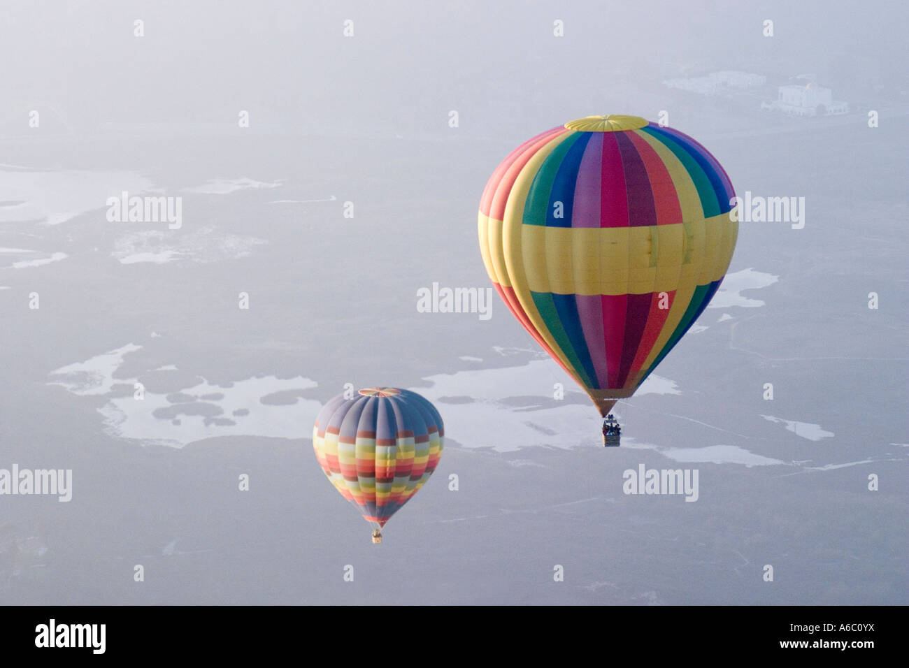 Due colorate mongolfiere visto dal di sopra, galleggiante su un brumoso paesaggio. Foto Stock