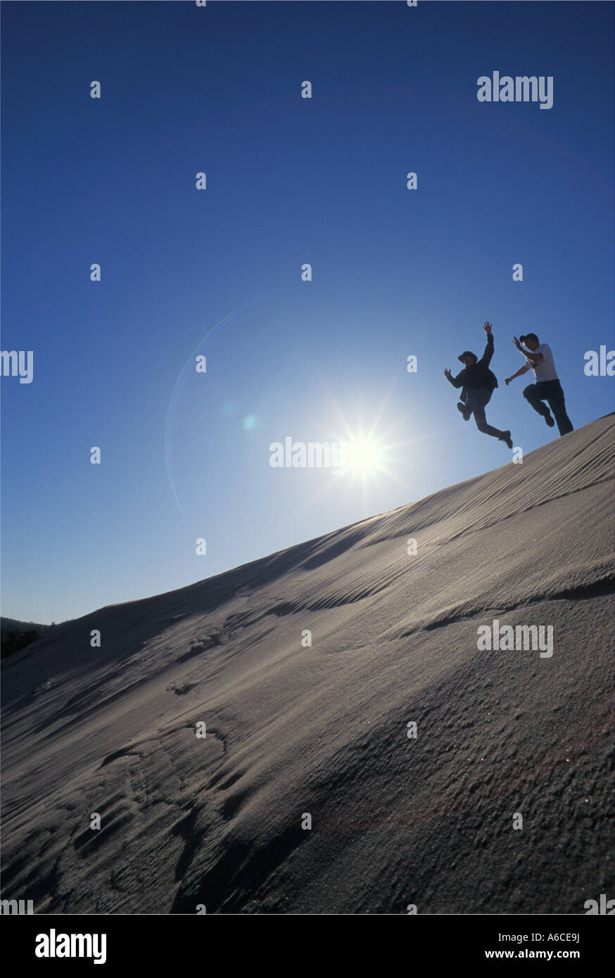 Due giovani uomini salta fuori da dune di sabbia ridge Umpqua Dune Oregon Dunes National Recreation Area Oregon Coast Foto Stock