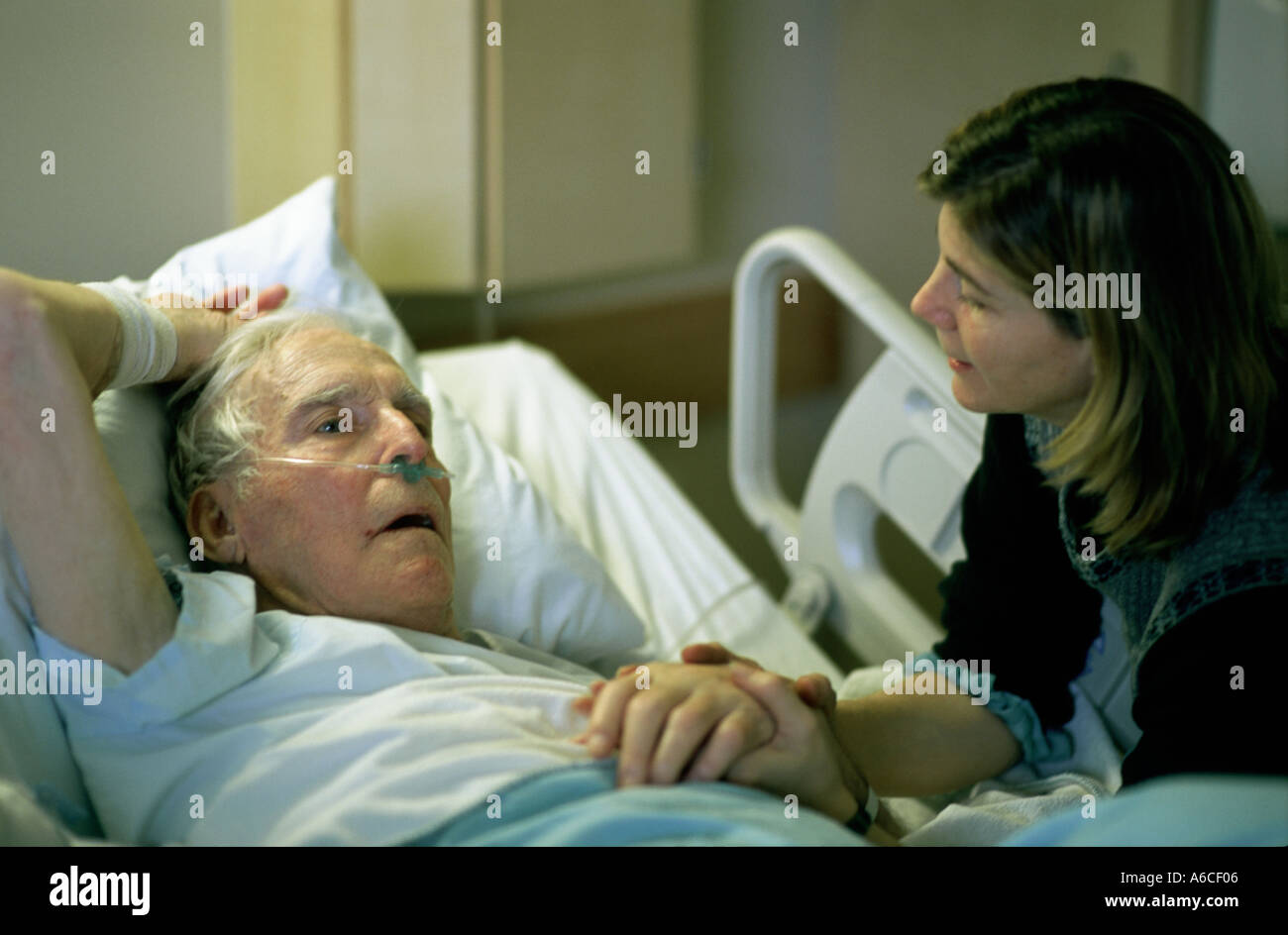 Figlia di conforto il suo padre malato in una stanza di ospedale Foto Stock