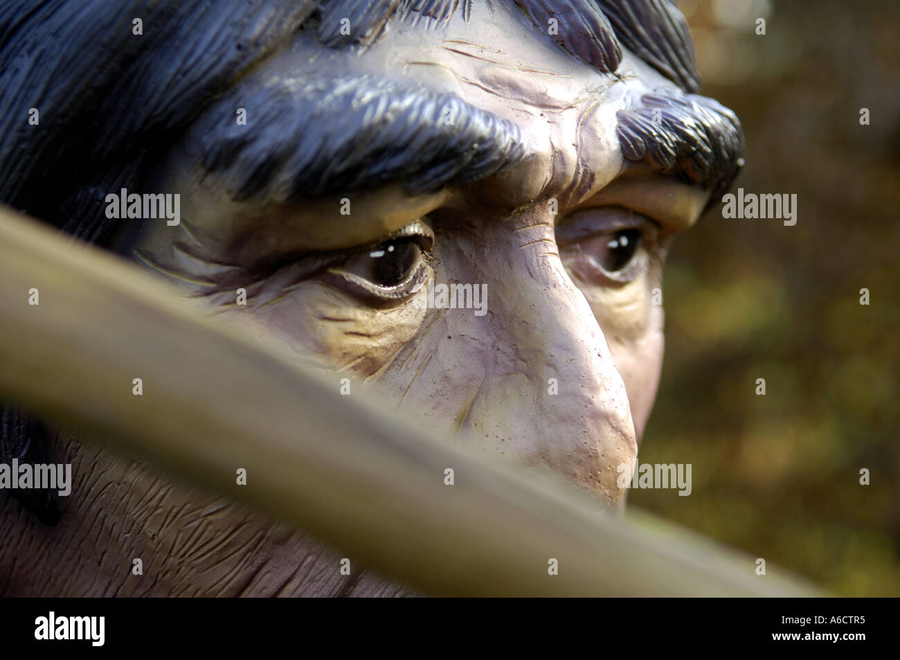 Preistorici faccia di testa grande occhio marrone uomo umano maschio umanoide armati di Neanderthal hunter lancia arma kill attacco Foto Stock