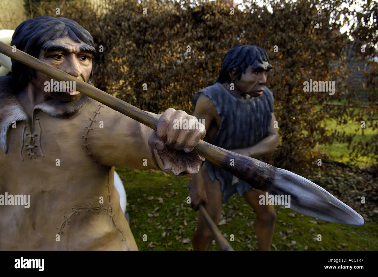 Preistorici faccia di testa grande occhio marrone uomo umano maschio umanoide armati di Neanderthal hunter lancia arma kill attaccare due Foto Stock