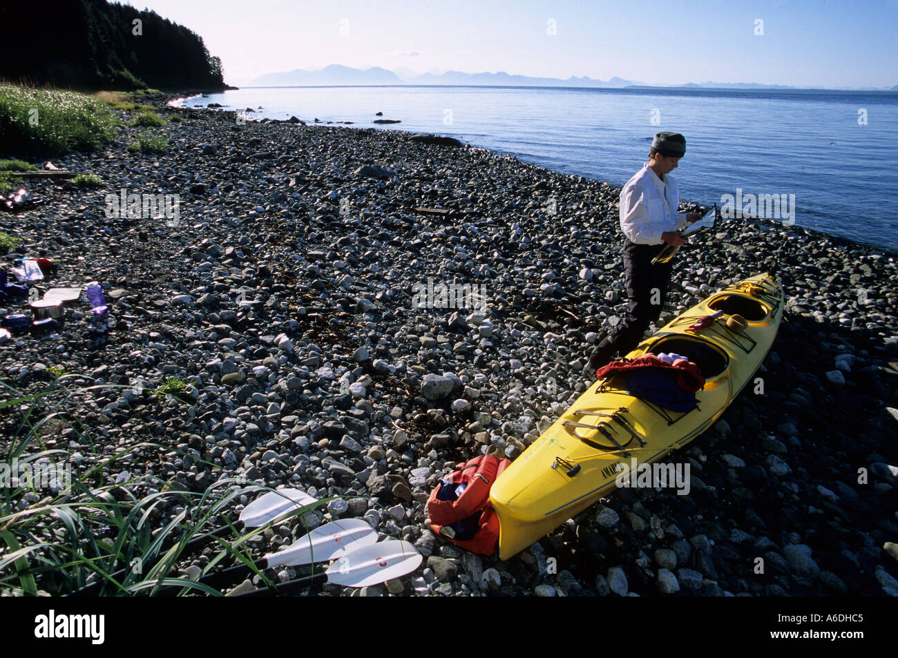Alaska Southeast Pt Adolphus Icy Strait donna mappa di lettura dal kayak di mare in una giornata di sole Fairweather montagne MR Foto Stock