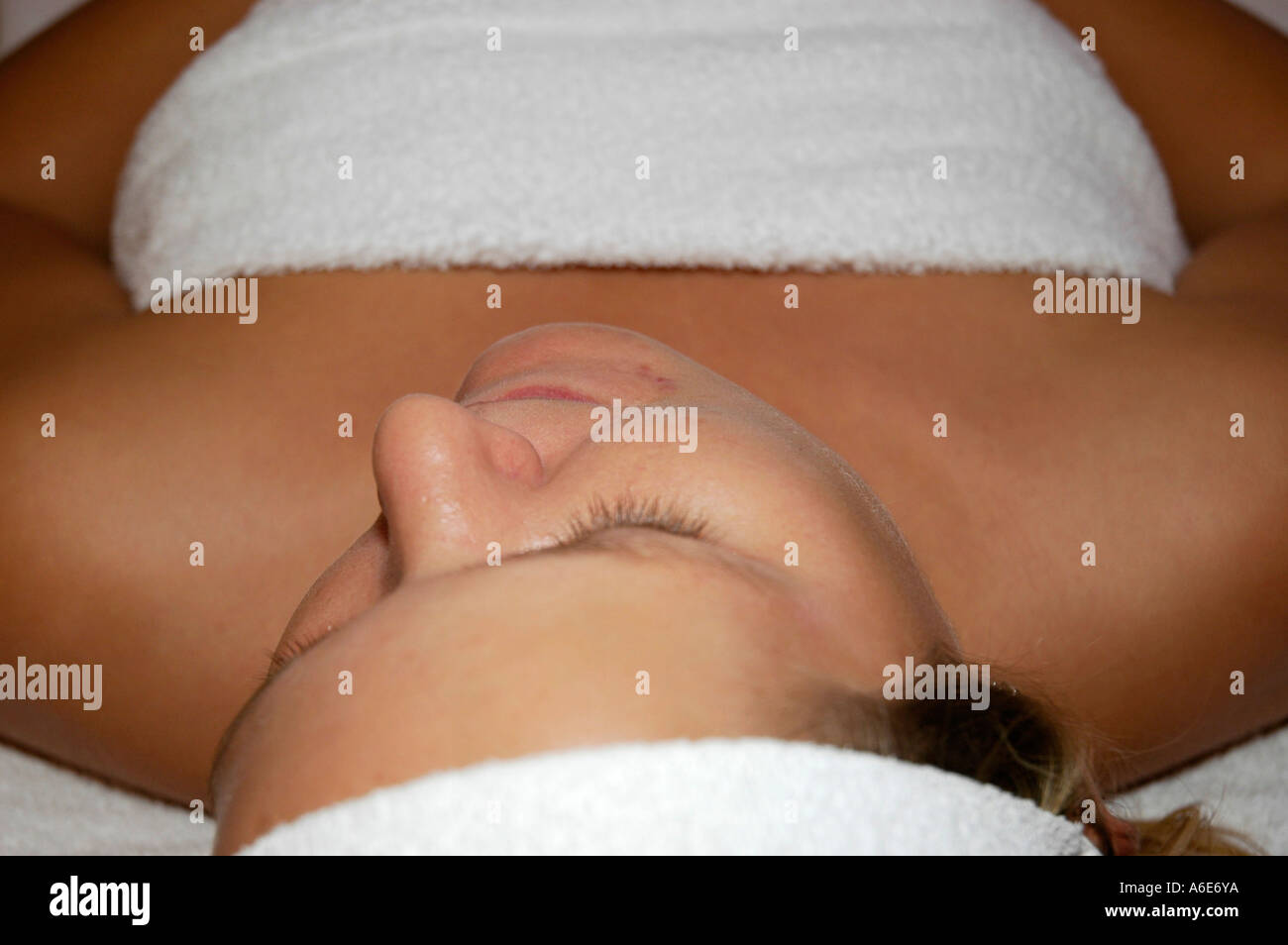 Giovane donna si trova sul retro e rilassa con gli occhi chiusi, cosmetici, benessere, Foto Stock