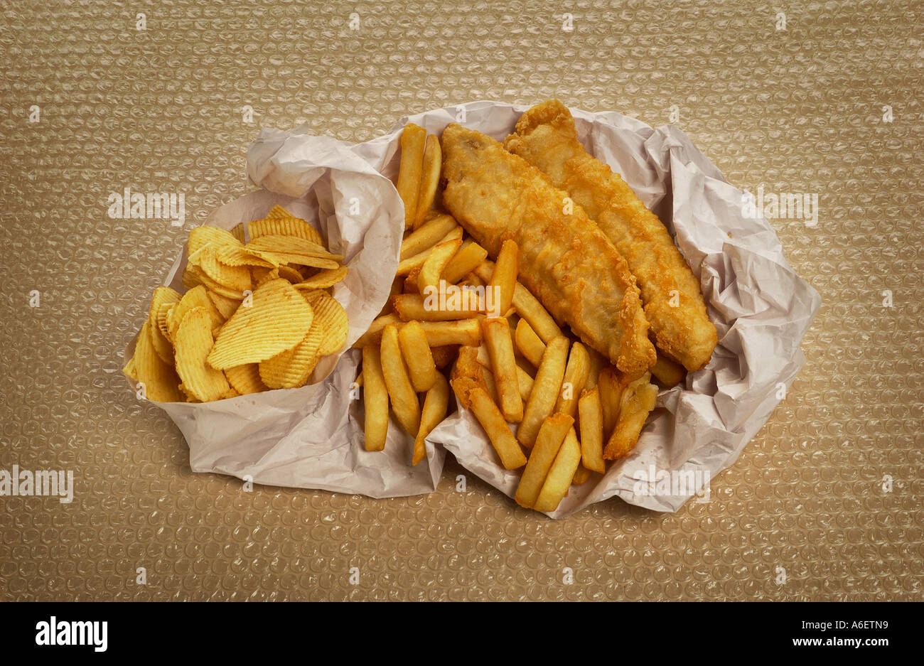 Scaglie di pesce avvolto nella carta Esempio di alta cibo grasso per essere consumato con moderazione Foto Stock