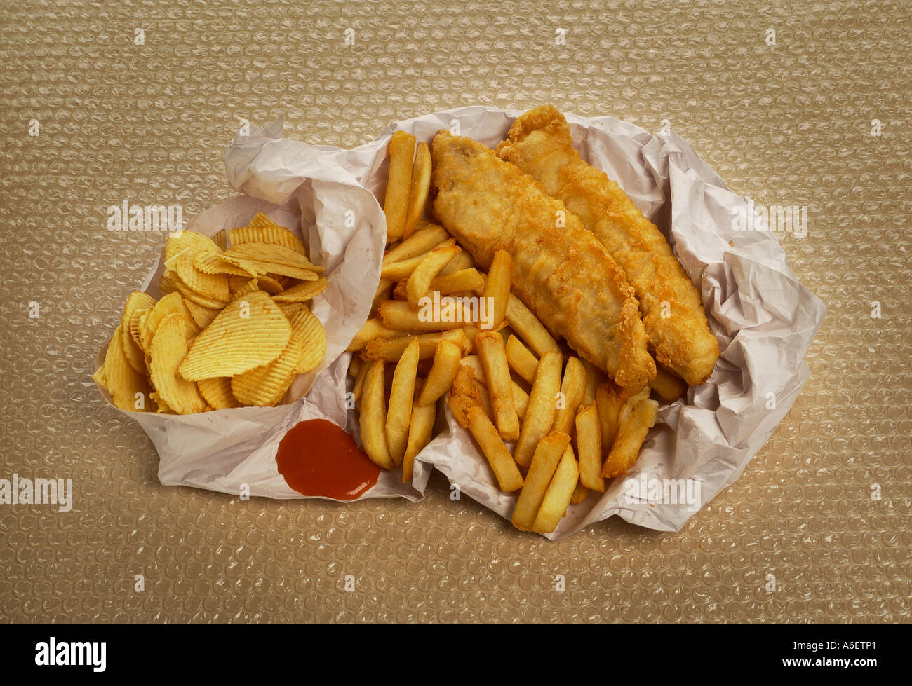 Scaglie di pesce avvolto nella carta Esempio di alta cibo grasso per essere consumato con moderazione Foto Stock