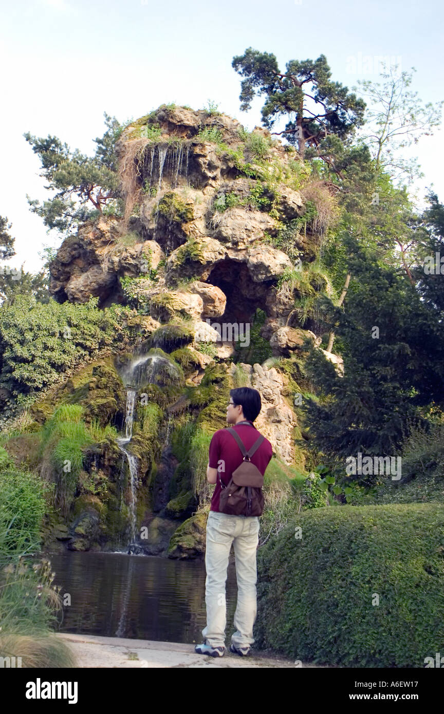 Parigi FRANCIA, Parchi urbani, Bois de Boulogne, giovane uomo asiatico godersi la natura in 'Bagatelle Giardini' cascata, da dietro Foto Stock