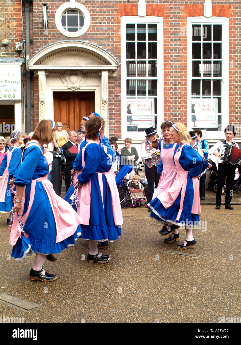 Femmine che indossa un tradizionale rosa e blu per intasare i ballerini custume durante un festival in Inghilterra Foto Stock
