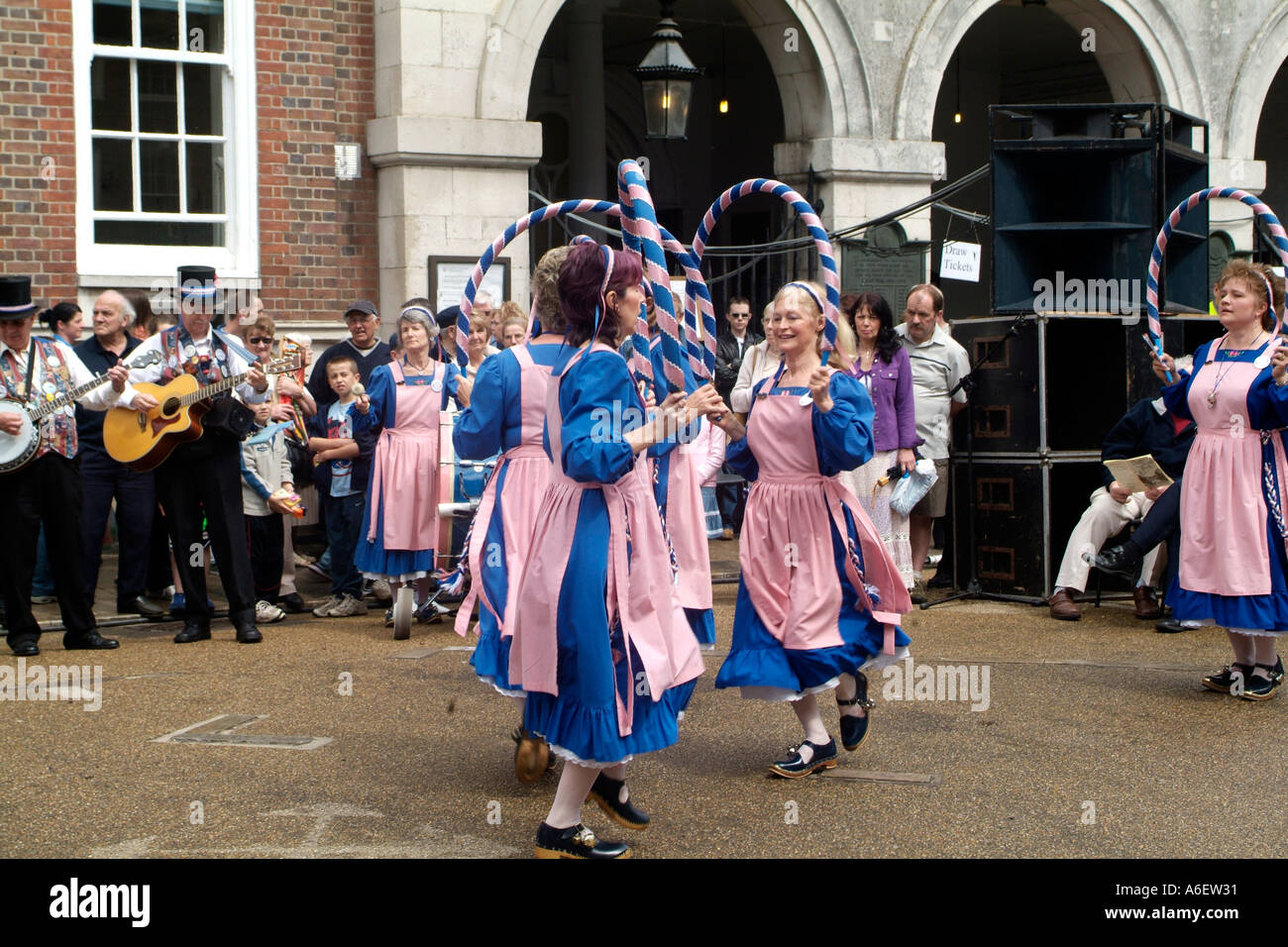 Femmine che indossa un tradizionale rosa e blu per intasare i ballerini custume durante un festival in Inghilterra Foto Stock