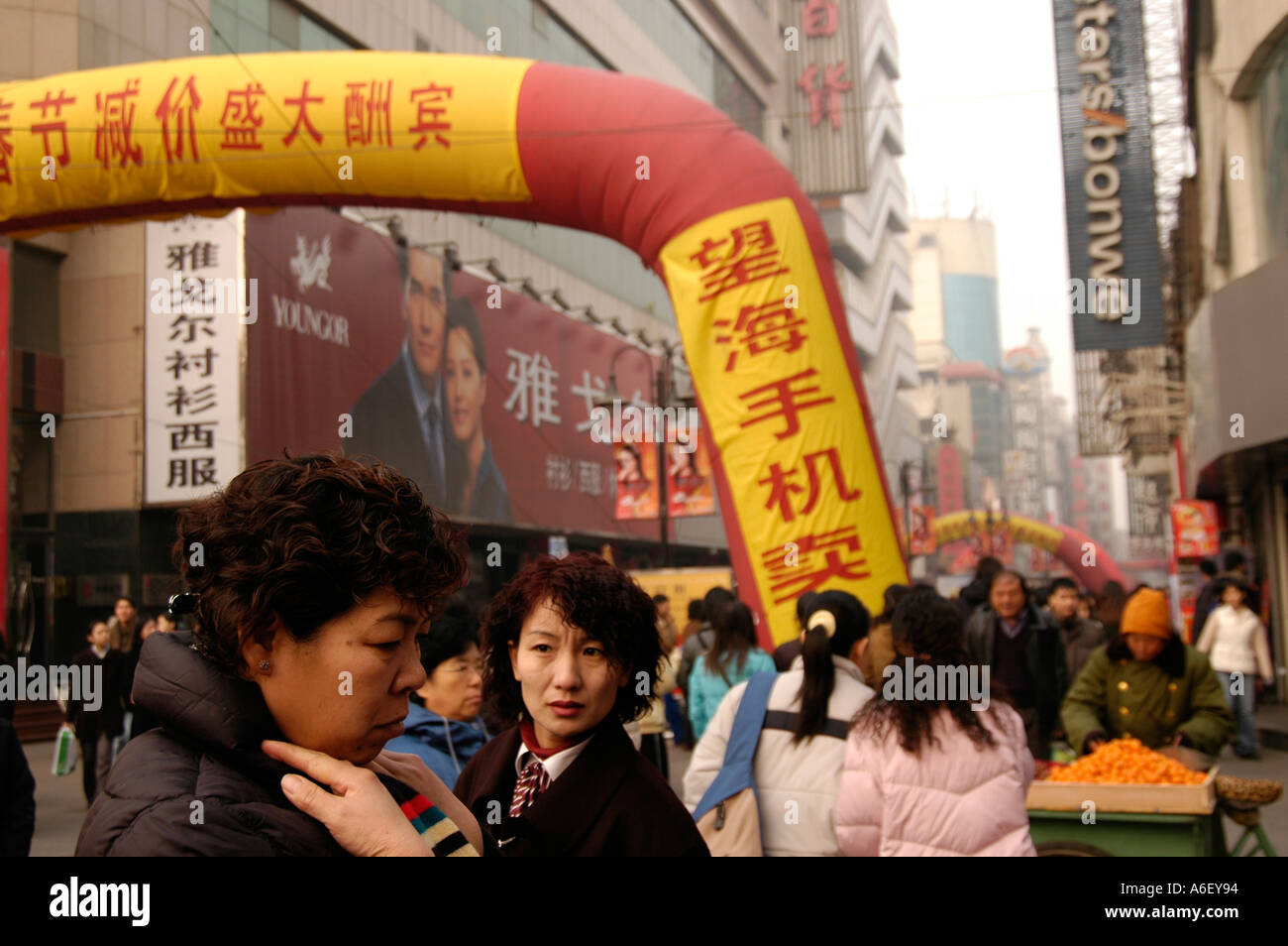 Donna emergente dalla folla in una strada pedonale di Tianjin centrum Cina Foto Stock