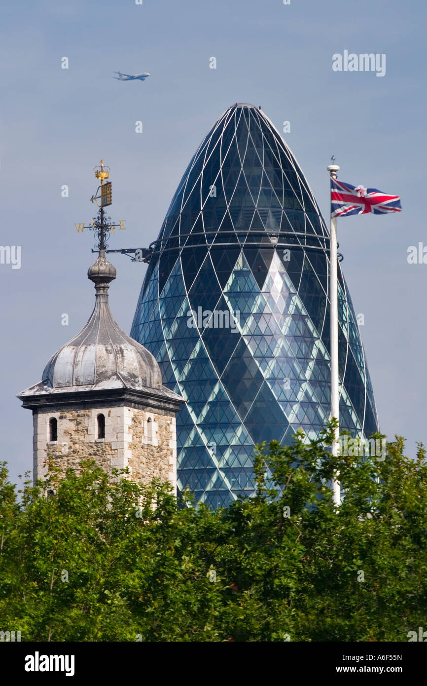 La Swiss Re Tower, la Torre di Londra, l'Unione Jack & un jet del passeggero Foto Stock