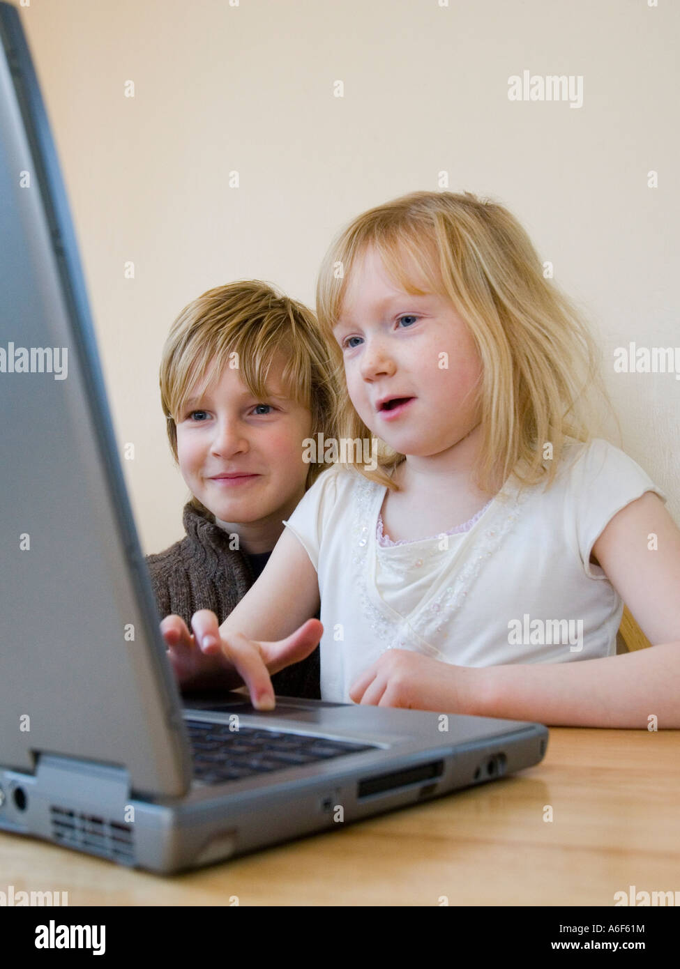 Ragazzo e ragazza utilizzando un computer portatile Foto Stock