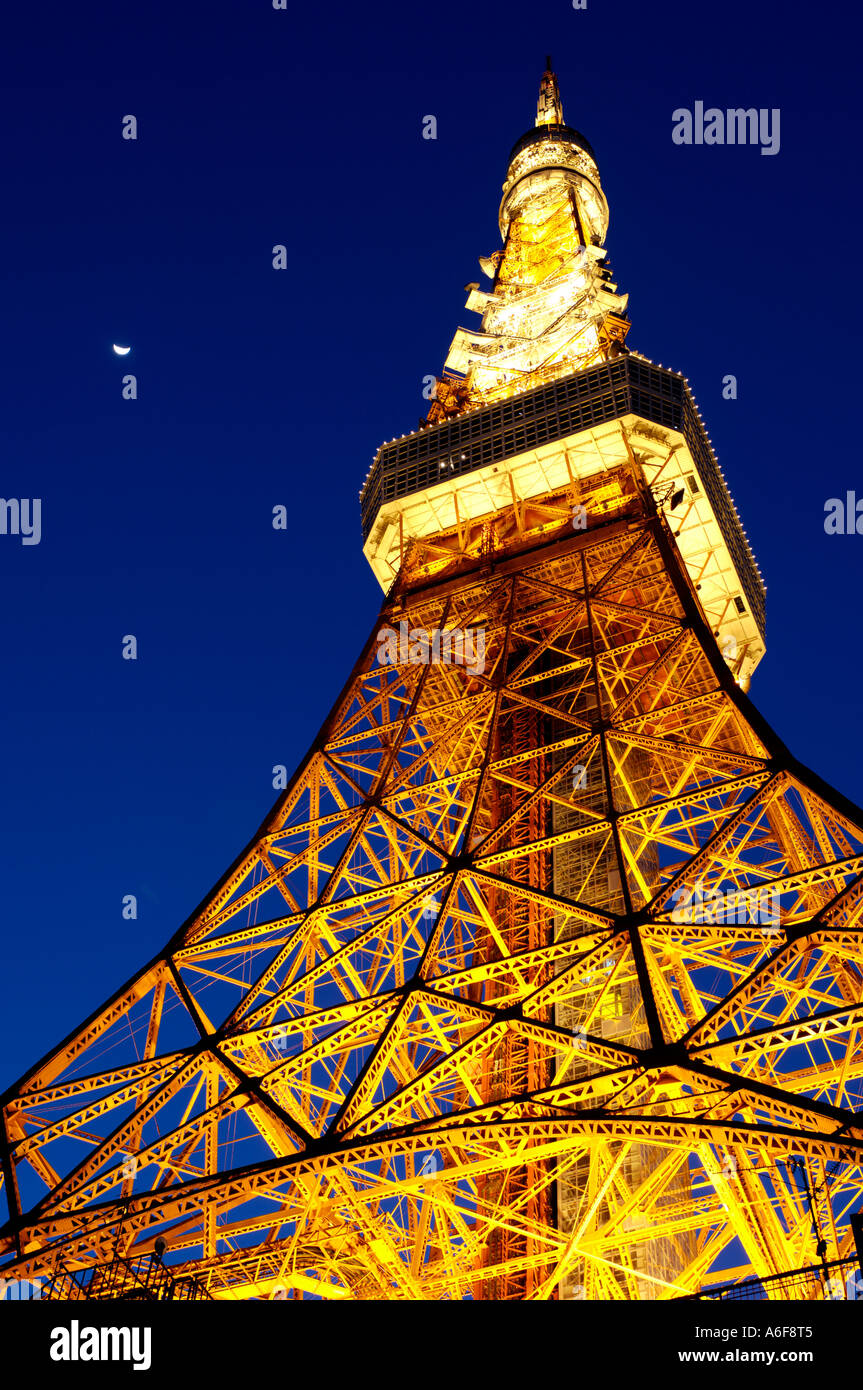 La torre di Tokyo illuminato con luci contro un blu scuro del cielo della sera con la luna nel cielo. Foto Stock