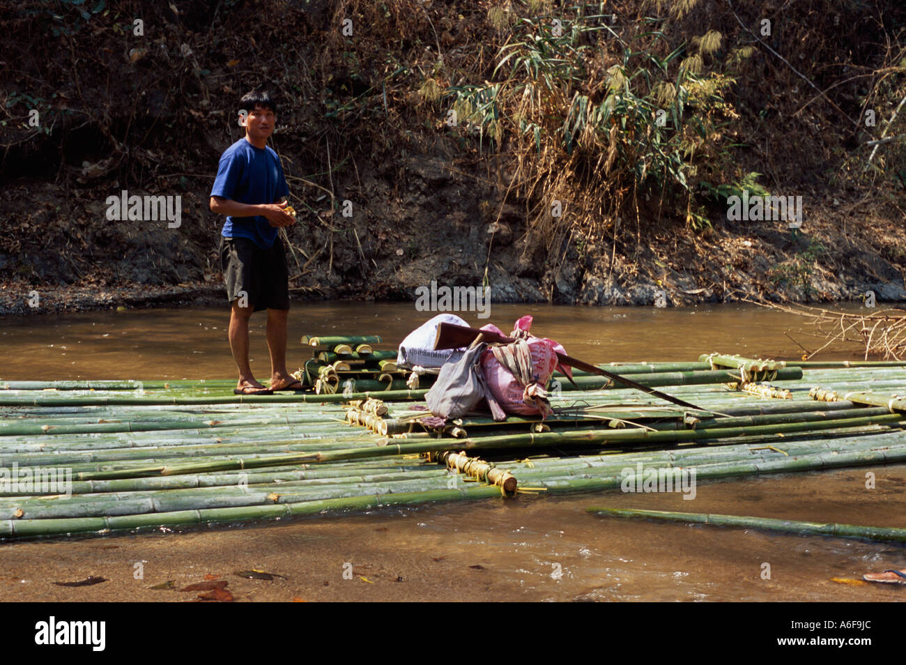 Shan trekking con guida a mano flintlock rifle e handmade zattera di bambù sul fiume Pai, Thailandia Foto Stock