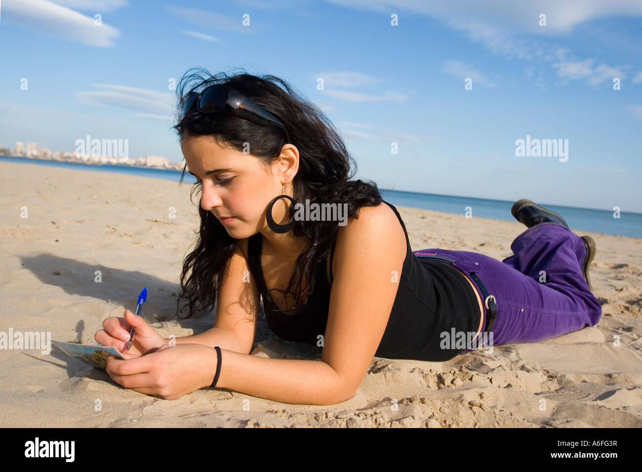 Giovane donna sdraiata sulla spiaggia. Foto Stock