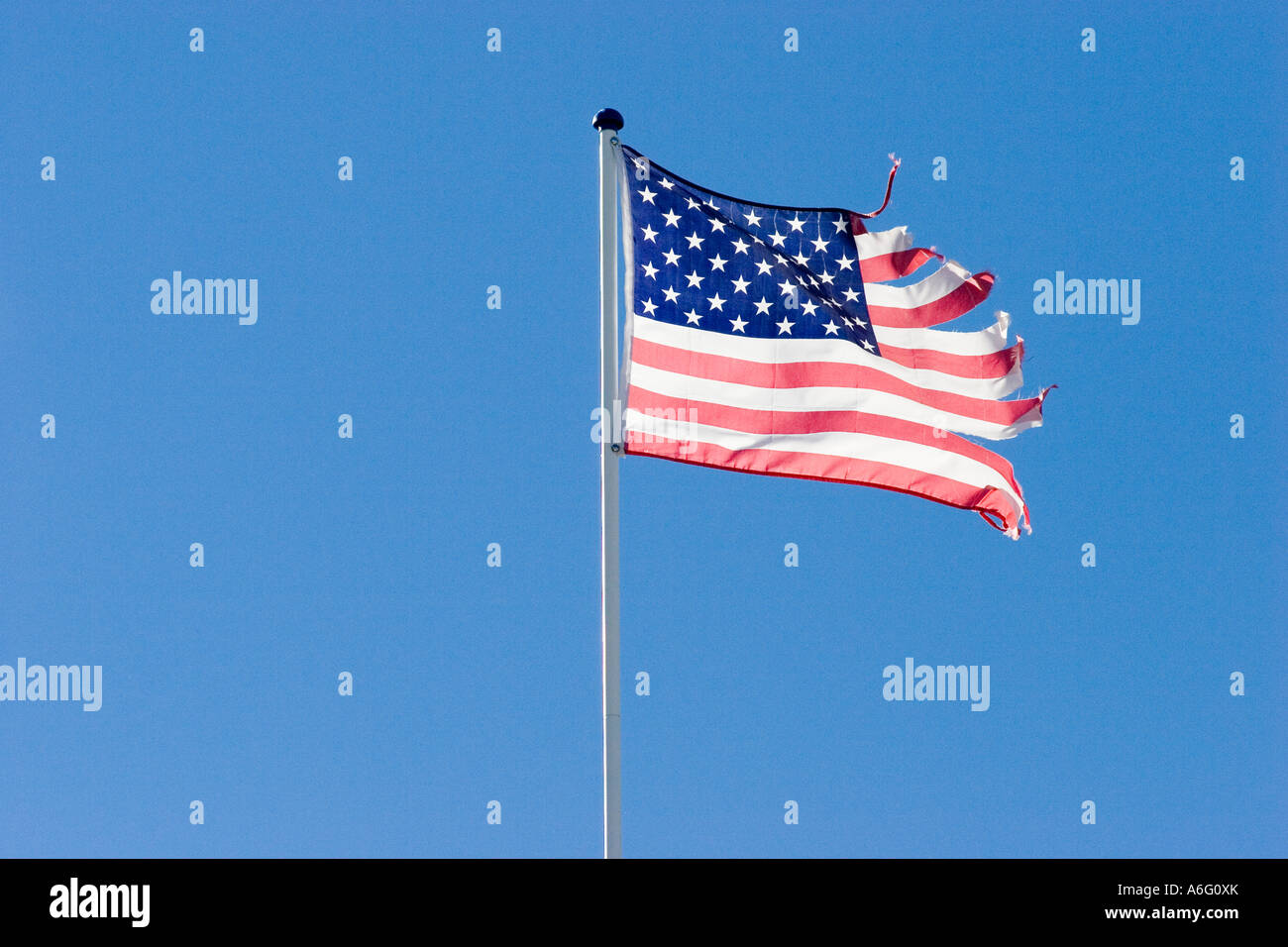 Bandiera degli Stati Uniti d'America nel cielo blu weathered strappato dopo venti forti o tempesta indietro luce accesa Foto Stock