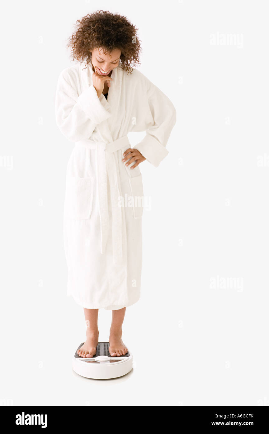 Donna in piedi sulla bilancia da bagno Foto Stock