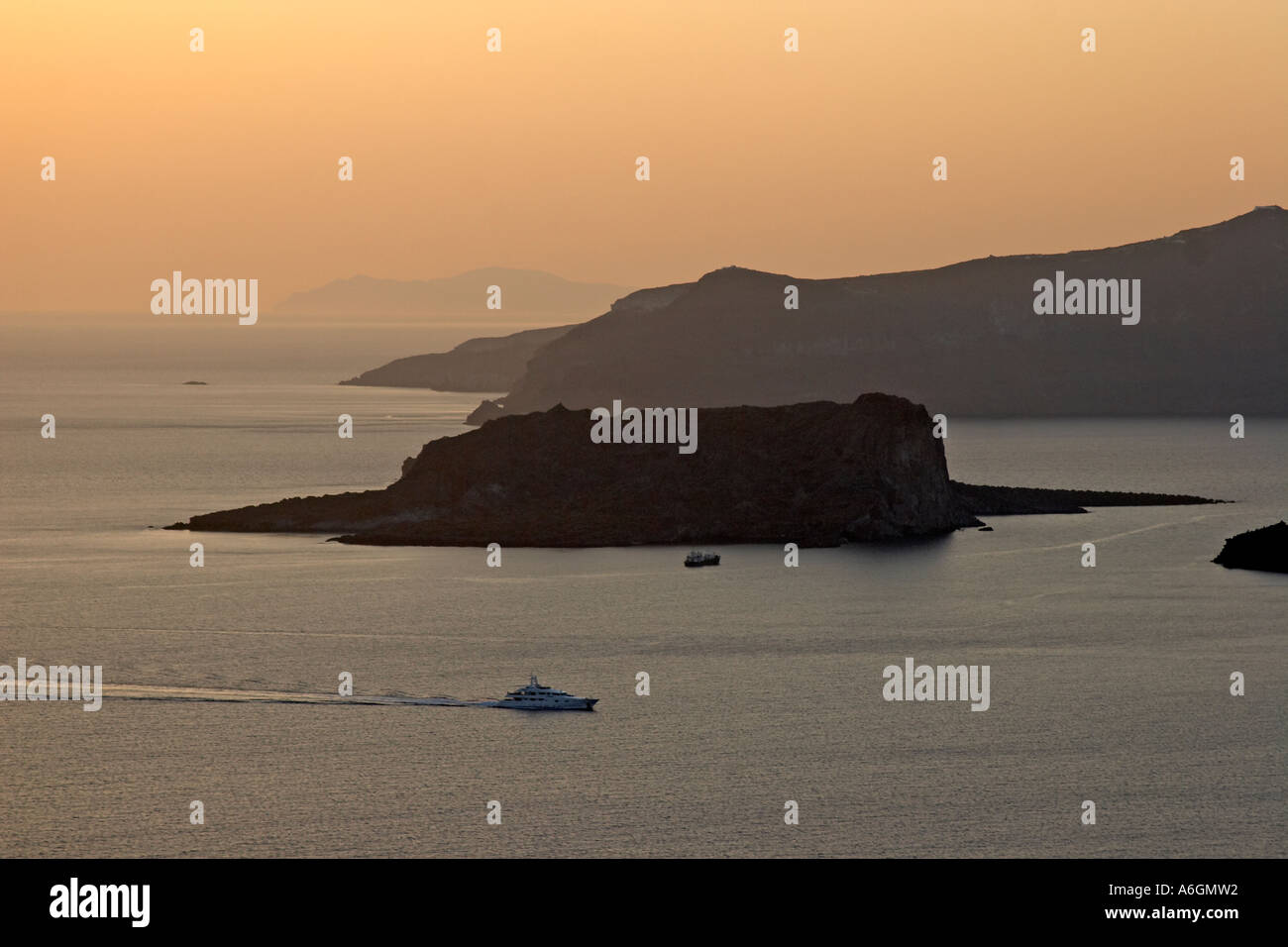 Nea Kameni island e di Thirassia; dietro con nave al tramonto tramonto dell'isola greca di Santorini o Thira Grecia Foto Stock