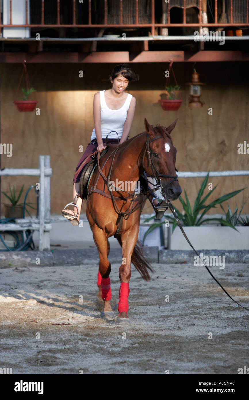 Giovane donna a cavallo centro equestre da spiaggia Cherating Malaysia Foto Stock