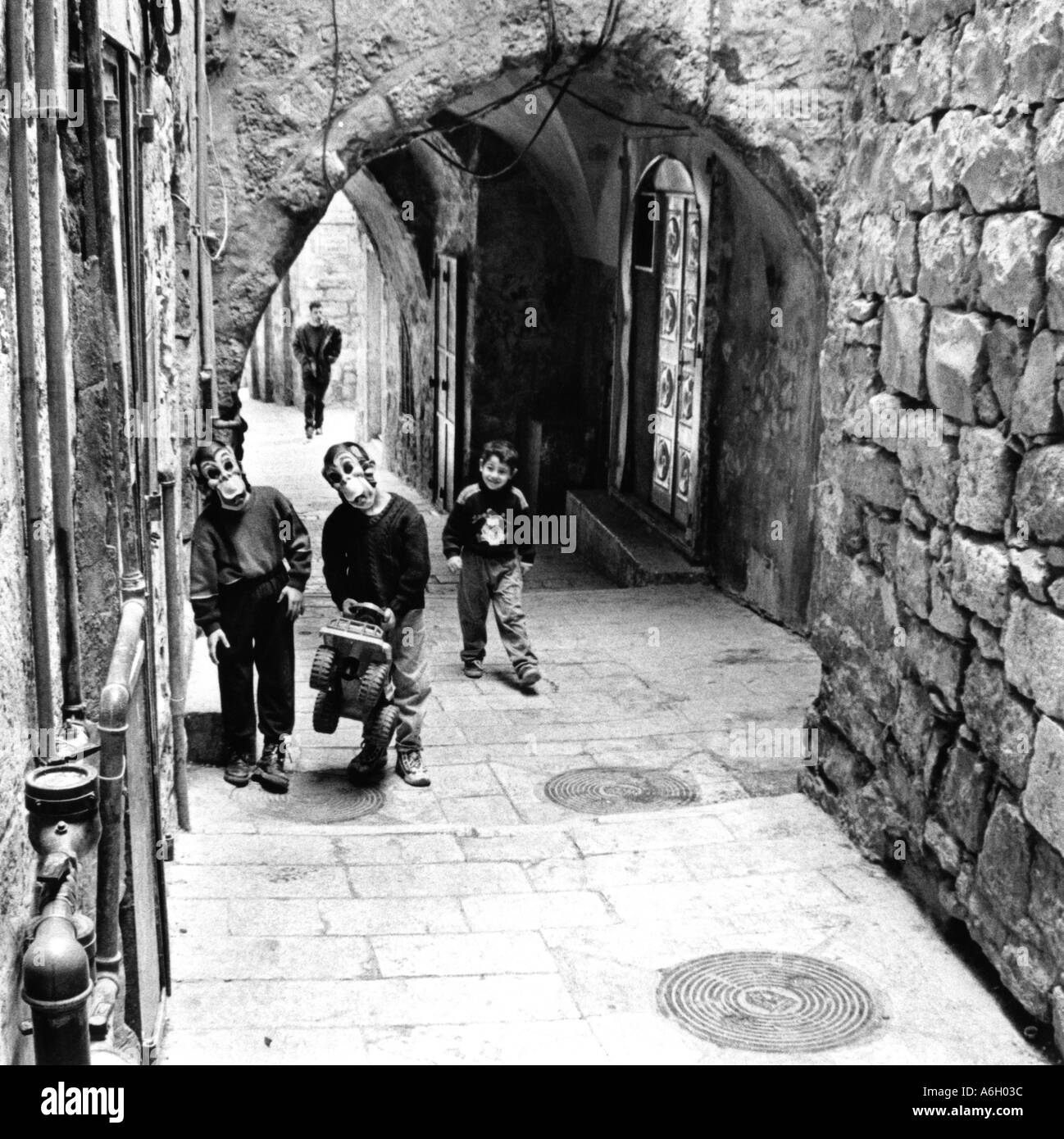 Israele Gerusalemme vecchia città 2 youg boys indossando maschere di scimmia a giocare in strada Foto Stock