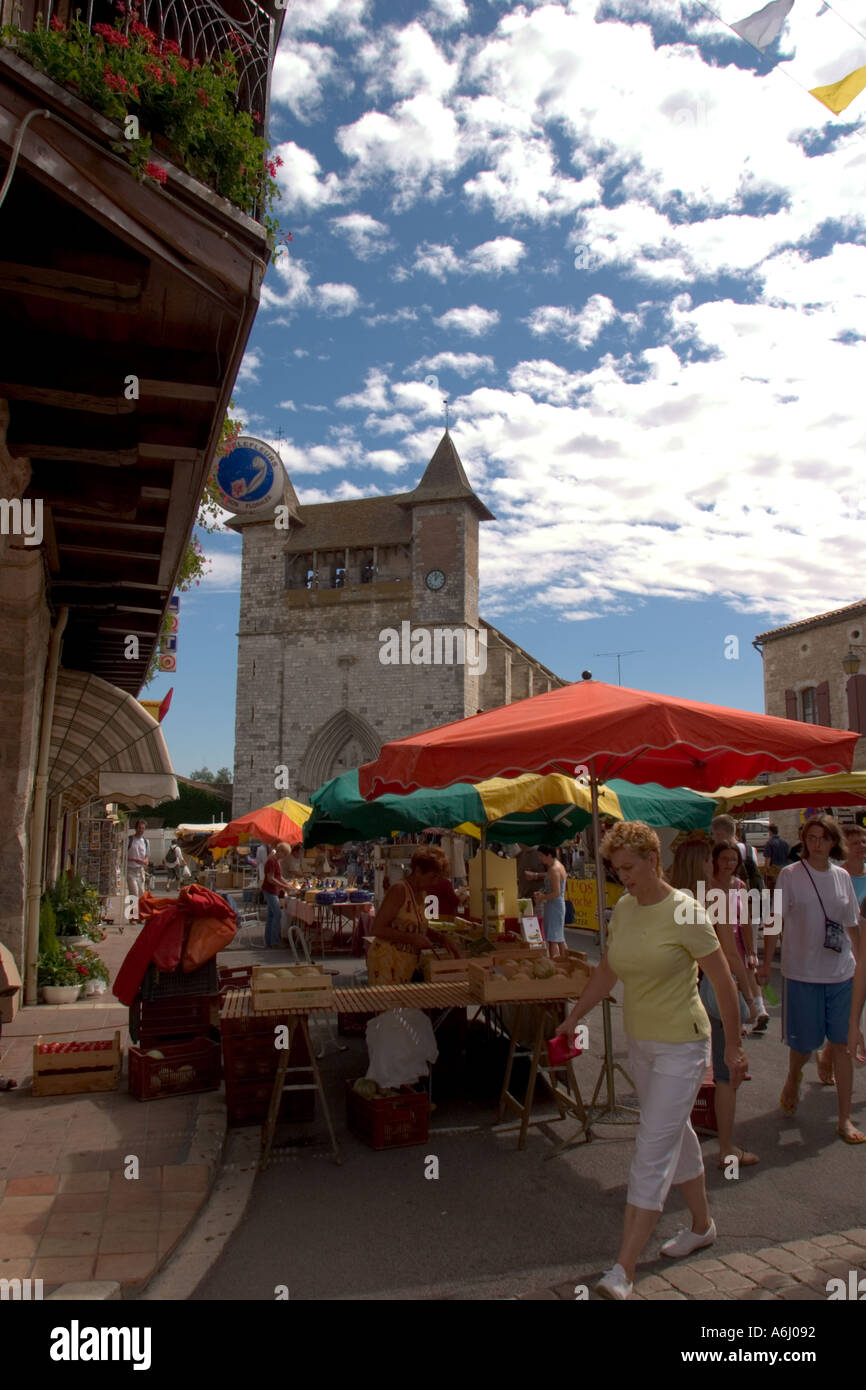 Occupato mercato medievale francese con tettoie colorate sopra le bancarelle, e le persone vestite in abiti estivi Monflanquin Sud-Ovest Francia ue Foto Stock