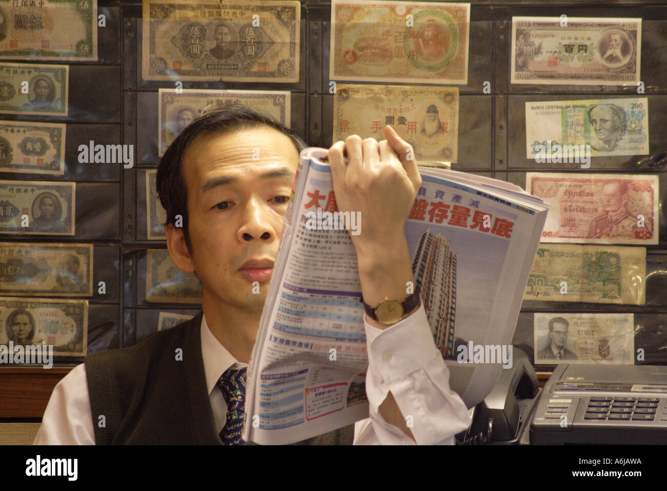 Hong Kong SAR, Cina, Caricatore di denaro in tutto il mondo Plaza la lettura della carta nella parte anteriore della moneta internazionale Foto Stock