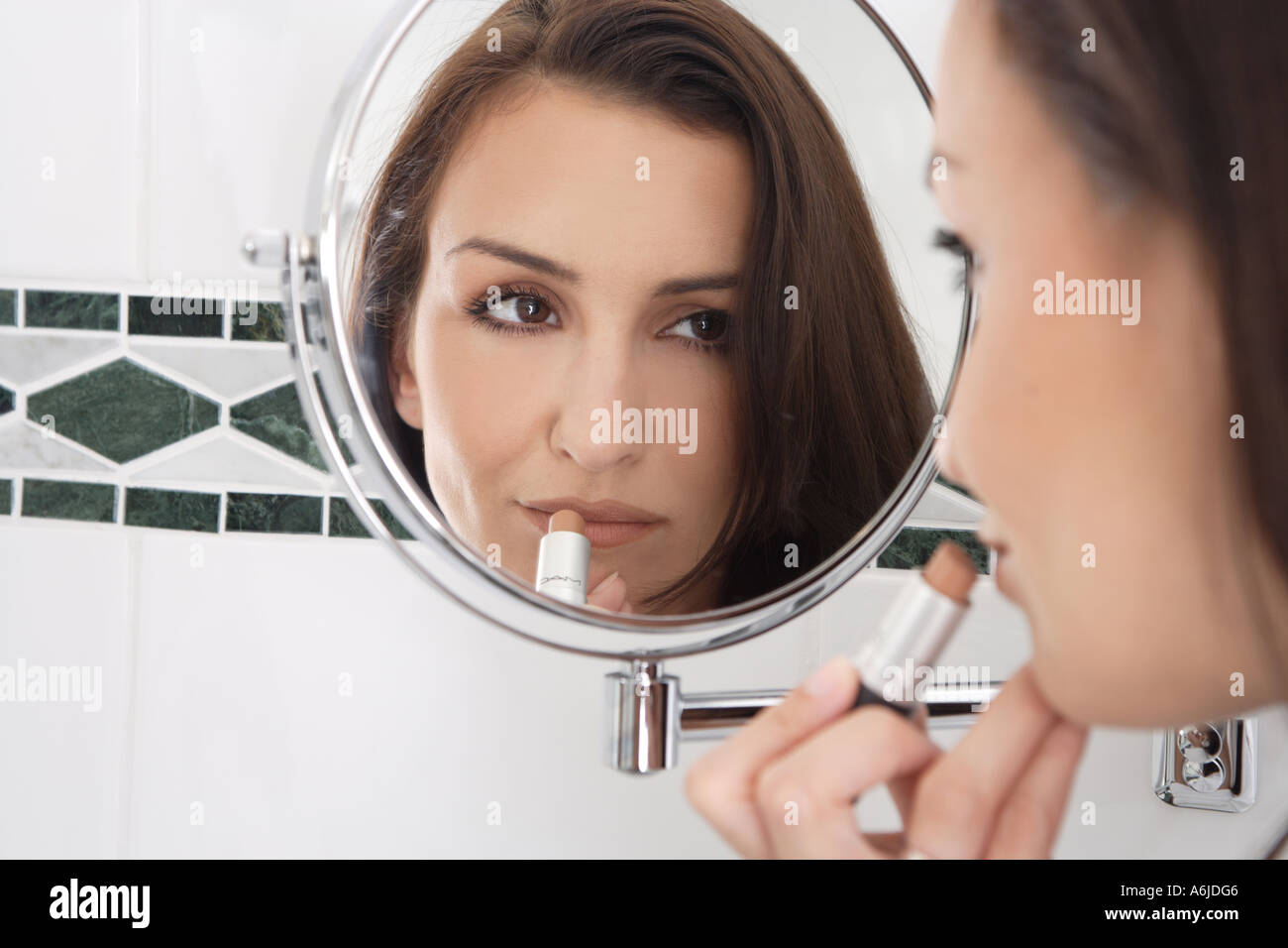 L'immagine speculare della giovane donna che compongono le sue labbra Foto Stock