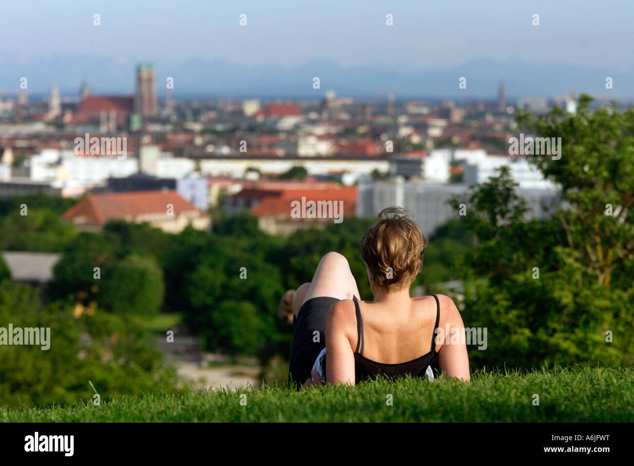 La donna in un parco guardando la città vecchia di Monaco di Baviera, Germania Foto Stock