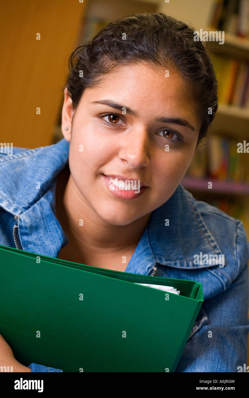 STUDENTESSA etnica asiatica faccia adolescente ragazza studentessa 14-16 anni con la sua cartella di studio fiducioso attraente ritratto sorridente nella biblioteca di riferimento della scuola Foto Stock
