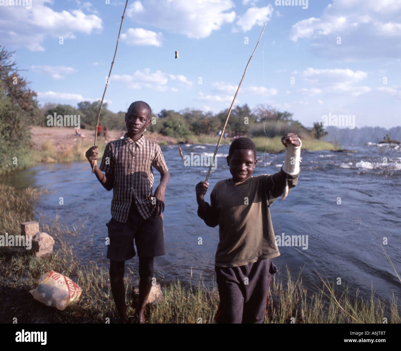 Ragazzi che pescano in cima alle cascate, Cascate Vittoria (mosi-oa-Tunya), Livingstone, Provincia meridionale, Repubblica dello Zambia Foto Stock