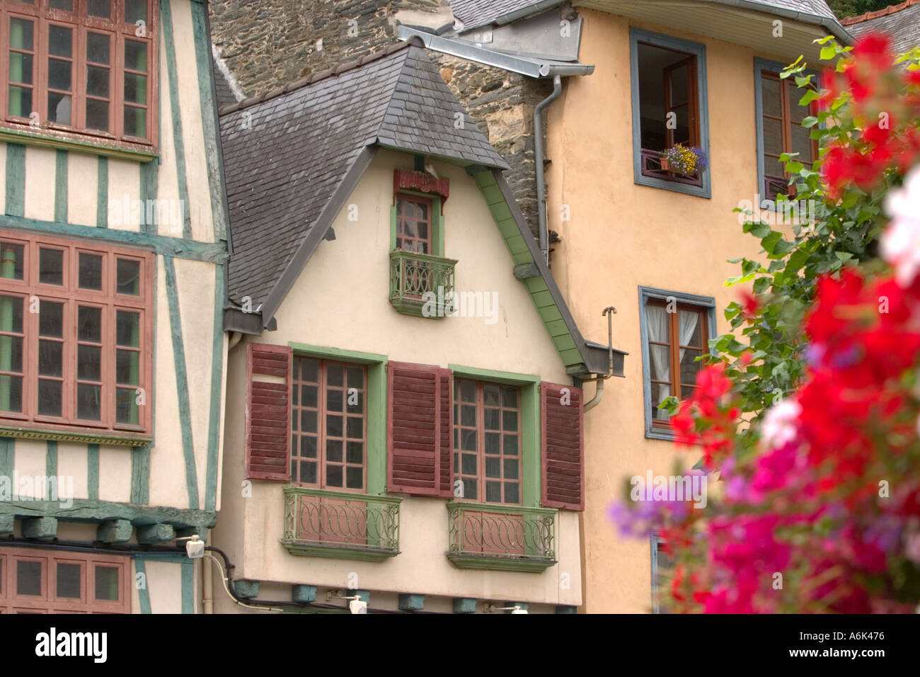 Finestre e persiane su edifici medievali senza messa a fuoco Fiori in primo piano in Morlaix Bretagna francia ue Foto Stock